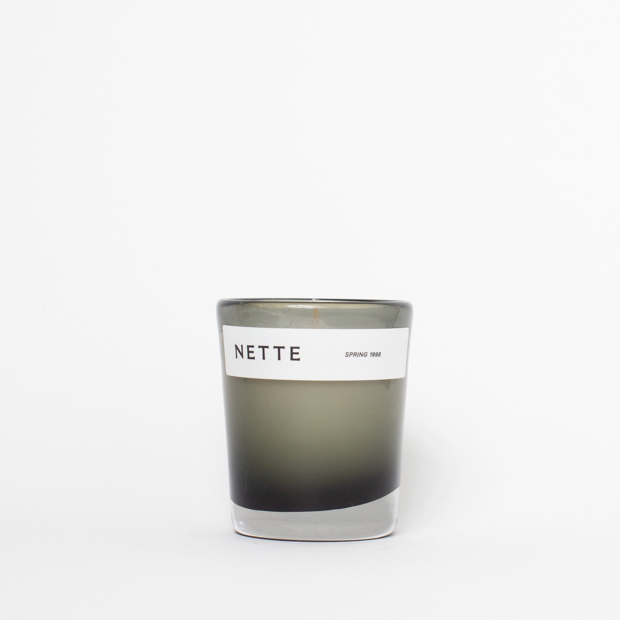 Candle with a 'NETTE' label on a white background