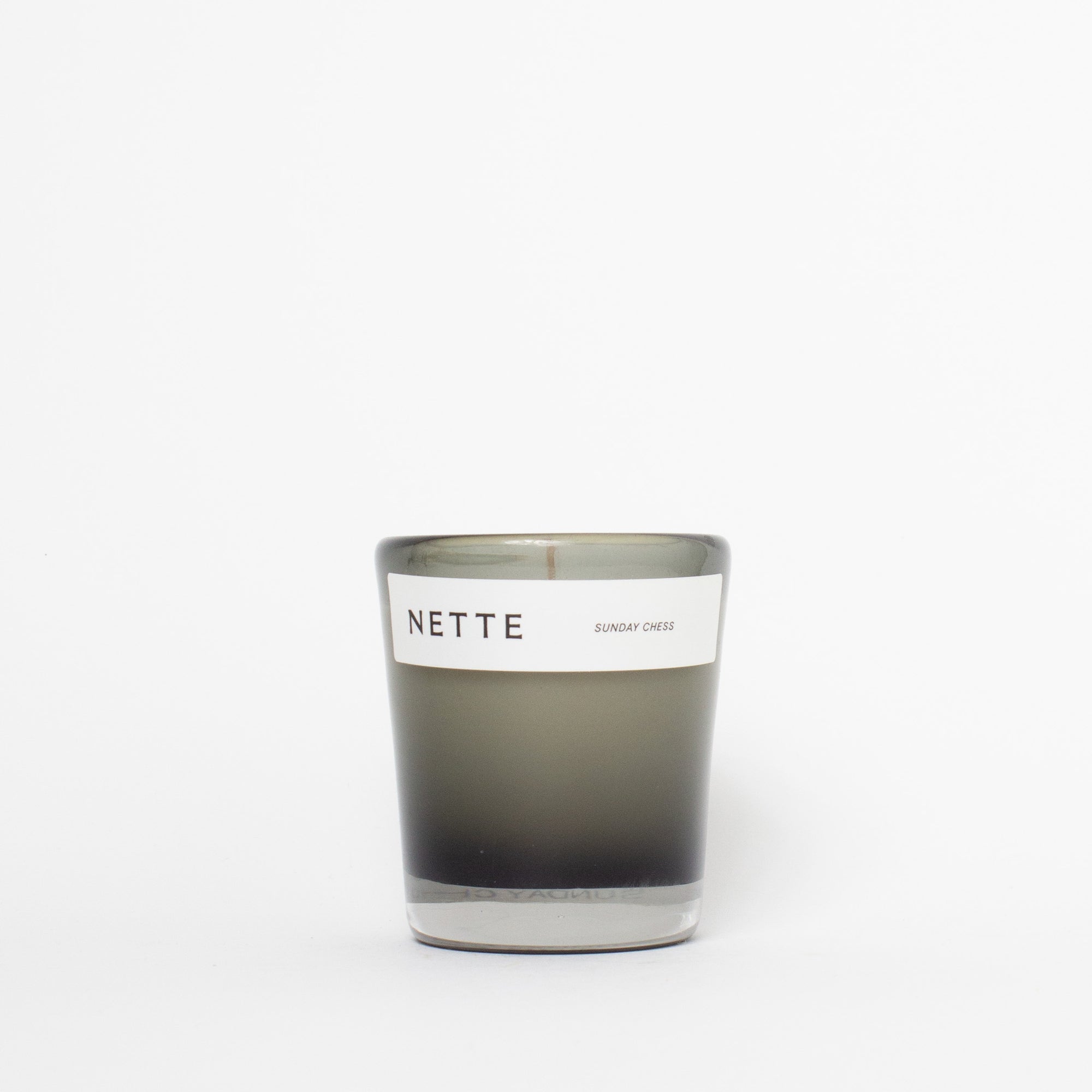 Candle with 'NETTE' label on a white background