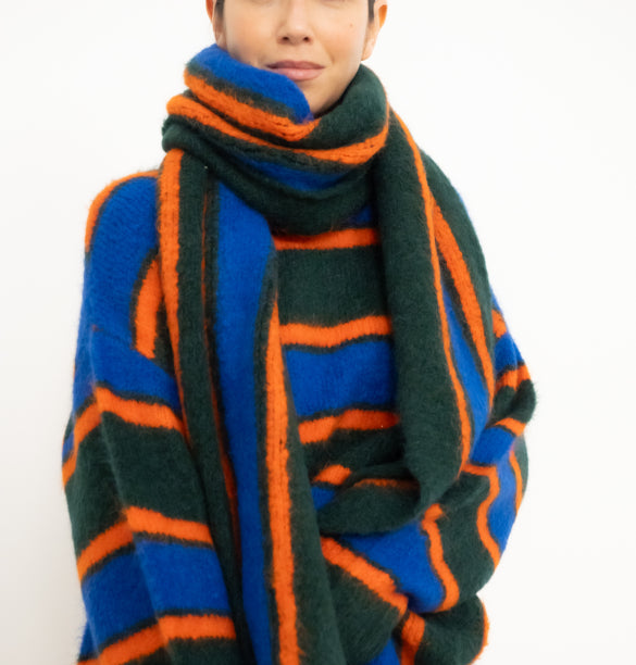 Person wearing a colorful striped scarf on a white background