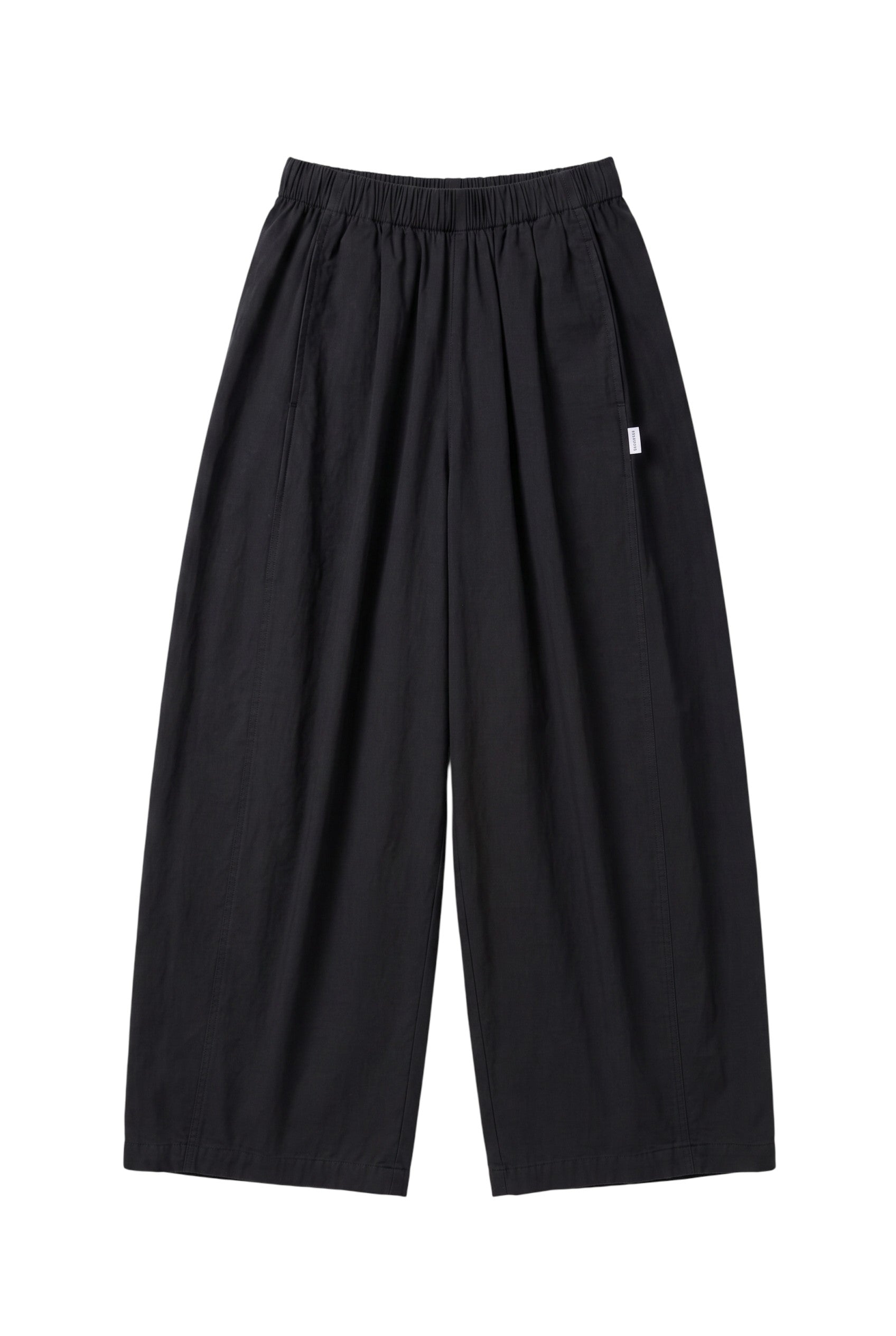 The Sunday Standard black cotton parachute pants with an elastic waist, side pockets, and a wide-leg sculptural fit.
