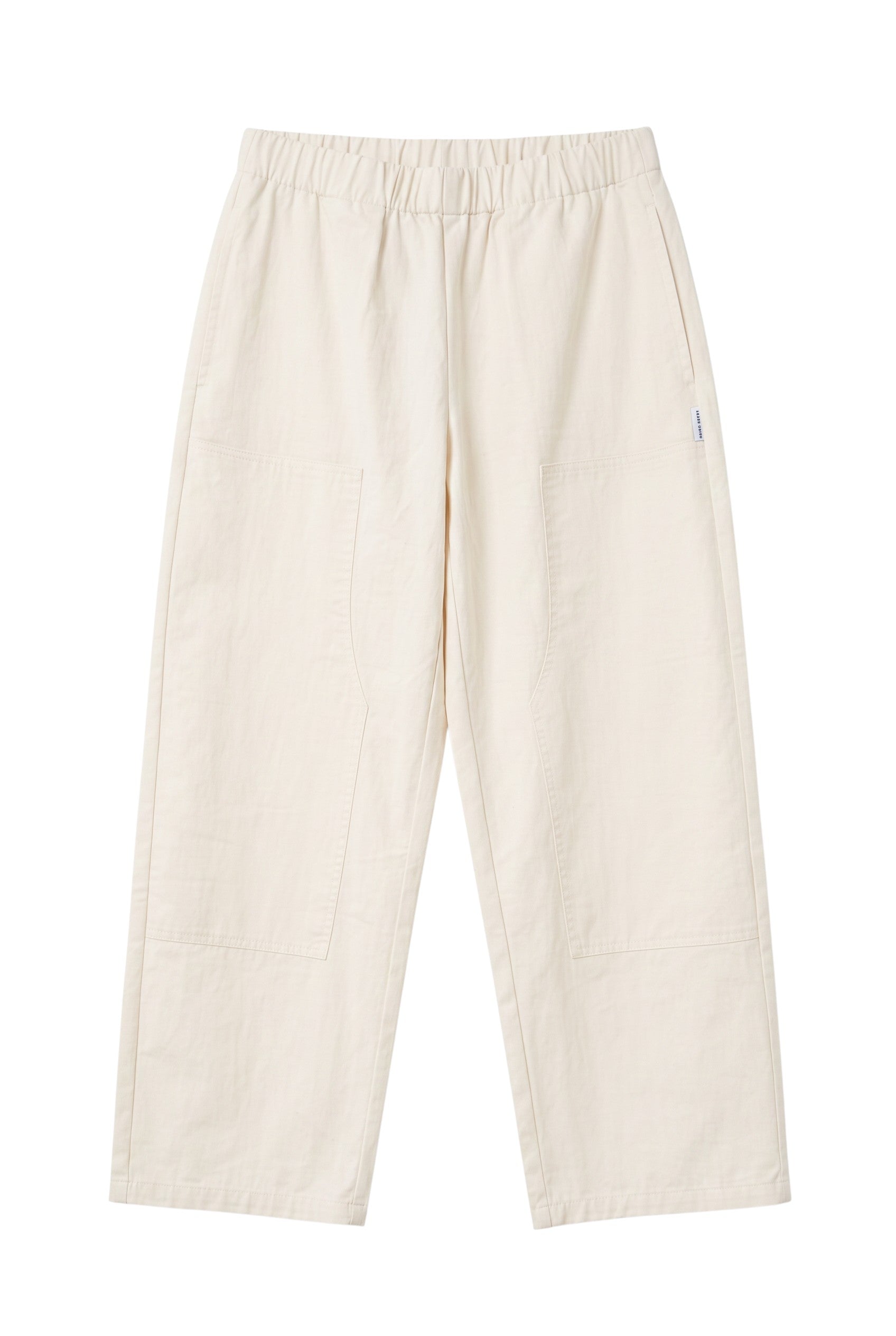 The Sunday Standard Gardener's Pants in cream cotton-nylon with an elastic waist, tapered leg, and utility patches.